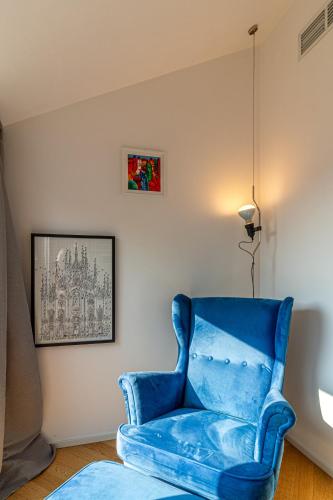 a blue chair in a room with a picture on the wall at My cup of tea in Seregno