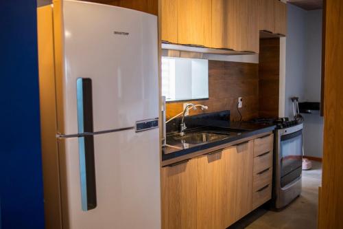 a kitchen with a white refrigerator and a sink at Chão de estrelas|vista701 in Alter do Chao