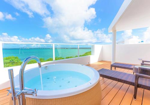a bath tub on a balcony with a view of the ocean at Blue Ocean Hotel&Resort MIYAKOJIMA in Miyako-jima