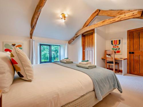 a bedroom with a large bed and a desk at 2 Bed in Bude 64088 in Marhamchurch