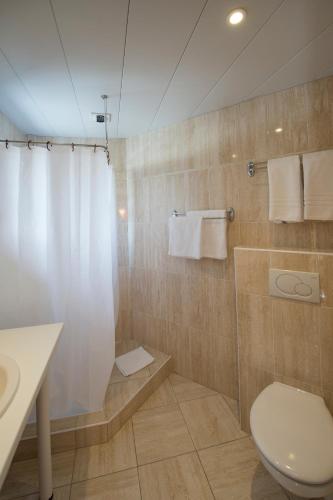 une salle de bain avec une douche avec des toilettes et un lavabo dans l'établissement Hôtel Esplanade Eden, à Lourdes