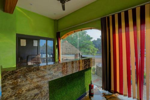 a green room with a counter with a window at HOTEL O Sk GRAND in Sitāpur