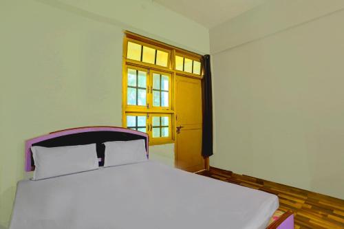 a white bed in a room with a window at HOTEL O Sk GRAND in Sitāpur