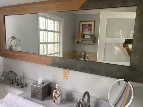 a person taking a picture of a bathroom mirror at Beautiful Villa by the Beach in Nassau
