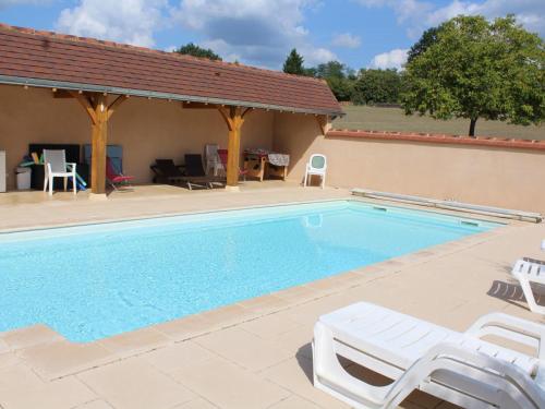 une piscine avec deux chaises et une maison dans l'établissement Maison de charme avec piscine chauffée dans le Périgord Noir, proche sites touristiques célèbres - FR-1-616-109, au Bugue