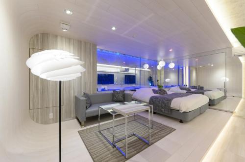 a bedroom with a bed and a couch at Hotel Aqua Vitae (Adult Only) in Nasu
