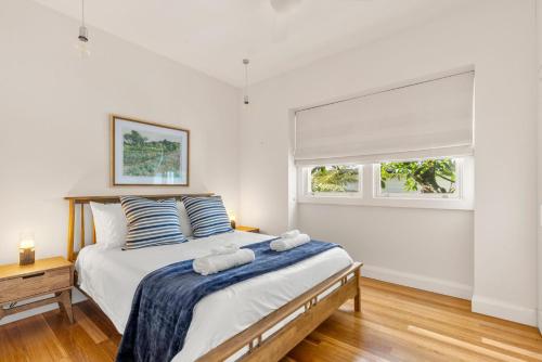 a bedroom with a bed with two towels on it at Brae View House - By Latitude South Coast in Berry