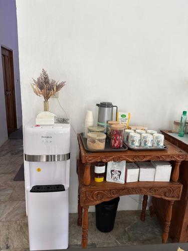 a small white refrigerator next to a table with food at Sea LaVie Guesthouse in Siquijor