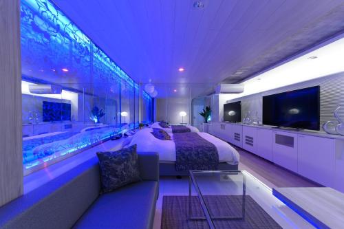 a bedroom with a large bed and a large aquarium at Hotel Aqua Vitae (Adult Only) in Nasu