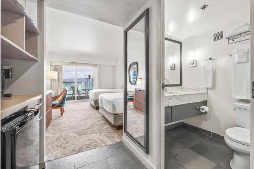 a bathroom with a toilet and a sink and a mirror at Top Floor Studio with Balcony & Views 3528 in Honolulu