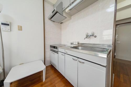 a white kitchen with a sink and a counter at スカイテラス那覇 in Naha