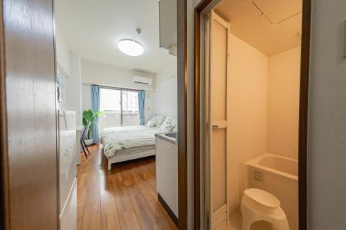 a small room with a bed and a bathroom at スカイテラス那覇 in Naha