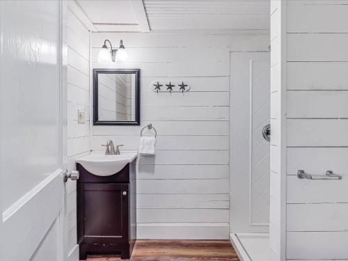 Un baño blanco con lavabo y espejo. en Bahia OZ RP105, en Rockport