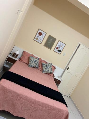 a bedroom with a bed with pink sheets and pillows at ORLA FLAT - Apartamento 02 in Bragança