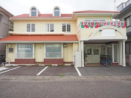 a store front of a building with a parking lot at マーケットステイ新宮 in Shingu