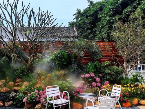 Nice holiday Resort-Guanhu beach Shenzhen في شنجن: حديقة فيها كرسيين وطاولة وزهور