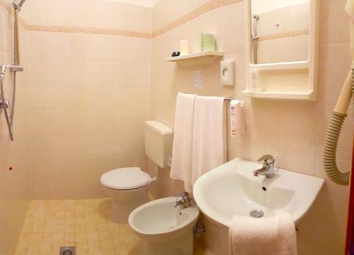 bagno bianco con lavandino e servizi igienici di Hotel Anna a Caorle