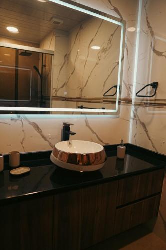a bathroom with a sink and a large mirror at Apartamento céntrico y lujoso in Cochabamba