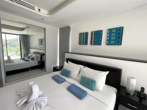 Un dormitorio con una gran cama blanca con almohadas azules. en Private apartment at Twin Sands by Lofty, en Patong Beach