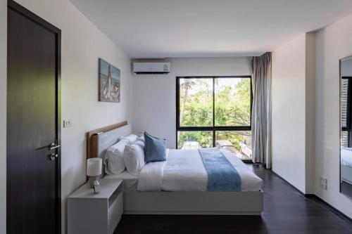 une chambre avec un lit et une grande fenêtre dans l'établissement Modern apartment at The Title by Lofty, à Ban Saiyuan (1)