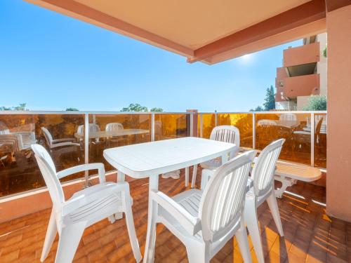 une table blanche et des chaises sur un balcon dans l'établissement Appartement 8 personnes avec Wi-Fi et vue sur mer - FR-1-827-29, à Roquebrune-Cap-Martin