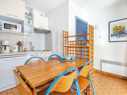 une cuisine et une salle à manger avec une table et des chaises en bois dans l'établissement Appartement 6 personnes avec Wi-Fi, proche de la mer - FR-1-827-42, à Roquebrune-Cap-Martin