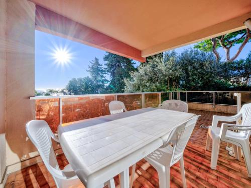une table et des chaises blanches sur une terrasse dans l'établissement Appartement 6 personnes avec Wi-Fi, proche de la mer - FR-1-827-42, à Roquebrune-Cap-Martin