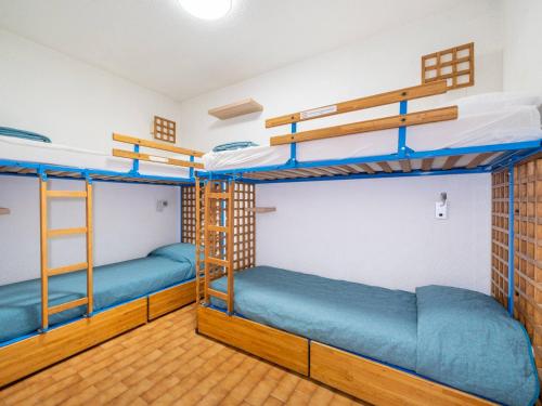 Deux lits superposés dans un dortoir avec des lits bleus dans l'établissement Appartement pour 8 avec Wi-Fi et vue sur mer - FR-1-827-24, à Roquebrune-Cap-Martin