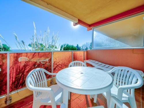 une table blanche et des chaises sur un balcon dans l'établissement Studio confortable avec Wi-Fi, pour 4, près de la mer - FR-1-827-47, à Roquebrune-Cap-Martin