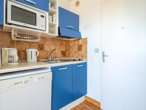 - une cuisine avec des placards bleus et un four micro-ondes dans l'établissement Studio confortable avec Wi-Fi, pour 4, près de la mer - FR-1-827-47, à Roquebrune-Cap-Martin