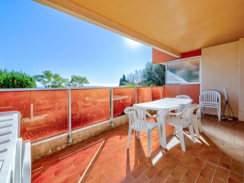 Elle comprend un balcon doté d'une table et de chaises blanches. dans l'établissement Appartement pour 8, spacieux séjour, vue mer, Wi-Fi inclus - FR-1-827-20, à Roquebrune-Cap-Martin