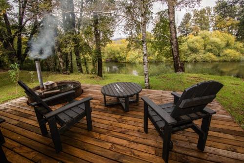 a wooden deck with two chairs and a grill and a table at Alto Terralis in Minetué