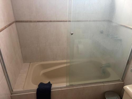 a bathroom with a bath tub with a glass door at Departamento Deluxe Cumbayá in Quito