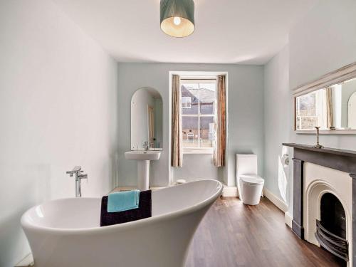 une baignoire blanche dans une salle de bain avec cheminée dans l'établissement 6 Bed in Dolgellau 91711, à Dolgellau