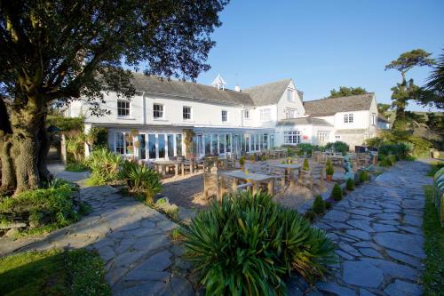 a large white building with tables and chairs at Talland Bay Hotel, Looe in Talland