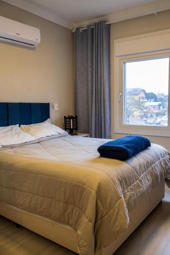 a bedroom with a large bed with a window at apto Casal Canela in Canela