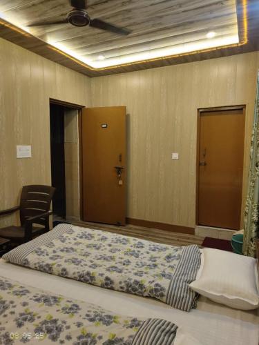 a large bed in a room with a ceiling at Gokul Guest House By Mero Pahad Stays & camp in Pāndukeshwar