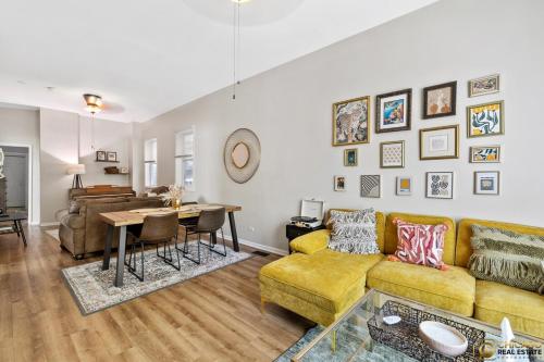 a living room with a yellow couch and a table at Prime Location Retreat 4 Bedrooms w Parking in Chicago