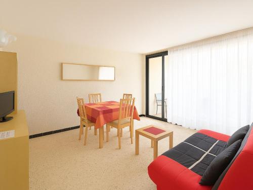 - un salon avec une table, des chaises et un canapé rouge dans l'établissement Appartement 4 Couchages à Argelès Plage, Proche Mer et Commodités - FR-1-732-62, à Argelès-sur-Mer