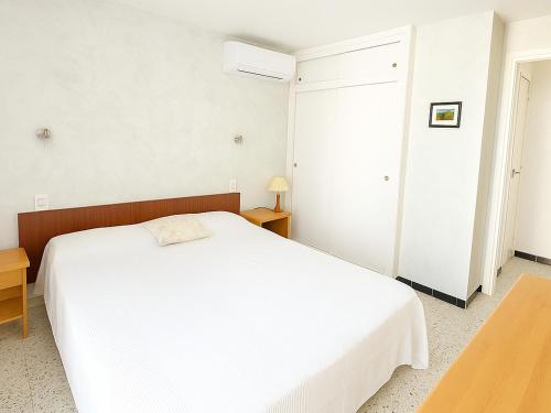 - une chambre blanche avec un lit blanc et une table dans l'établissement Appartement 4 Couchages à Argelès Plage, Proche Mer et Commodités - FR-1-732-62, à Argelès-sur-Mer