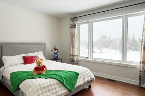a teddy bear sitting on a bed in a bedroom at Entire Home in Lake of Bays -Huntsville Muskoka Algonquin in Dwight