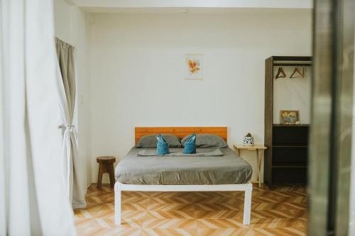 a bedroom with a bed with blue pillows at Pacifico Surf Bayay in San Isidro