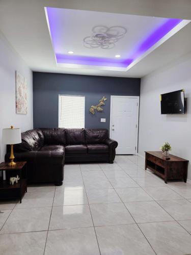 a living room with a leather couch and a tv at Apartment 3 bedrooms 40 minutes from South Padre in Weslaco