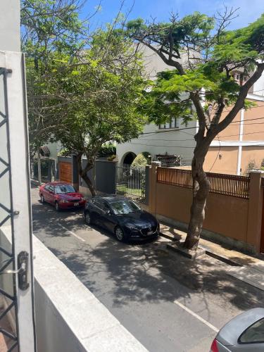 a car parked in a parking lot next to a tree at Casita de Ocharan Miraflores a dos calles de Larcomar in Lima