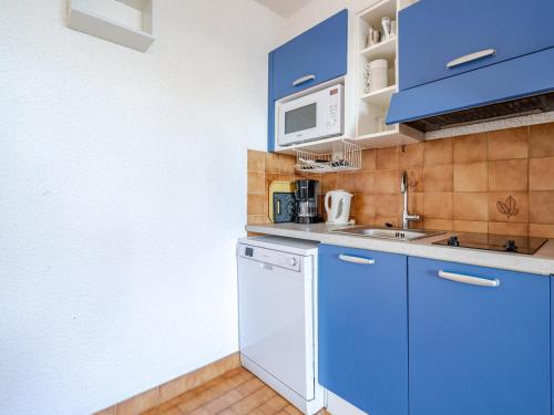 La cuisine est équipée de placards bleus et d'un lave-vaisselle blanc. dans l'établissement Studio confortable avec Wi-Fi, vue mer, 4 personnes - FR-1-827-60, à Roquebrune-Cap-Martin
