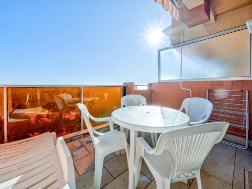 une table blanche et des chaises sur un balcon dans l'établissement Studio confortable avec WiFi pour 4 personnes à Roquebrune-Cap-Martin - FR-1-827-75, à Roquebrune-Cap-Martin