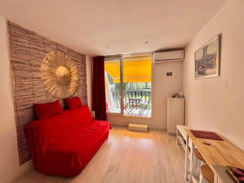 un salon avec un canapé rouge et une table dans l'établissement Studio climatisé avec parking près des plages - FR-1-716-85, à La Grande Motte