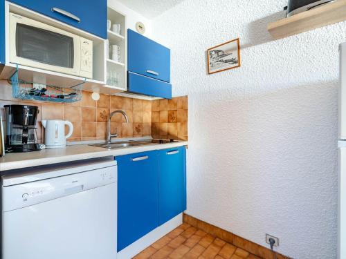 une cuisine avec des armoires bleues et un évier dans l'établissement Studio pour 4 avec Wi-Fi illimité, vue mer à Roquebrune-Cap-Martin - FR-1-827-66, à Roquebrune-Cap-Martin