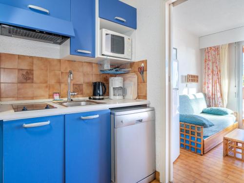 - une cuisine bleue avec évier et four micro-ondes dans l'établissement Studio cosy pour 4 à Roquebrune-Cap-Martin avec Wi-Fi - FR-1-827-76, à Roquebrune-Cap-Martin