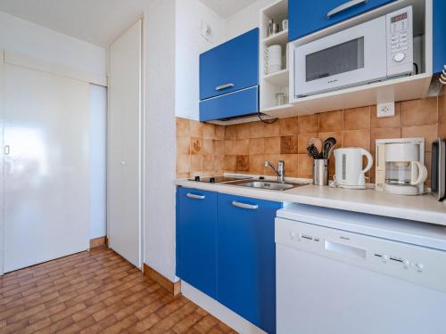 - une cuisine avec des placards bleus et un four micro-ondes dans l'établissement Studio confortable avec Wi-Fi illimité, vue mer, pour 4 personnes à Roquebrune-Cap-Martin - FR-1-827-52, à Roquebrune-Cap-Martin